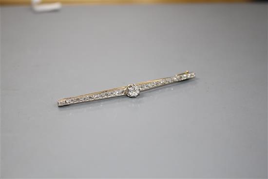 A 1920s yellow and white metal, diamond bar brooch, with central old cut diamond and millegrain set rose cut diamonds,